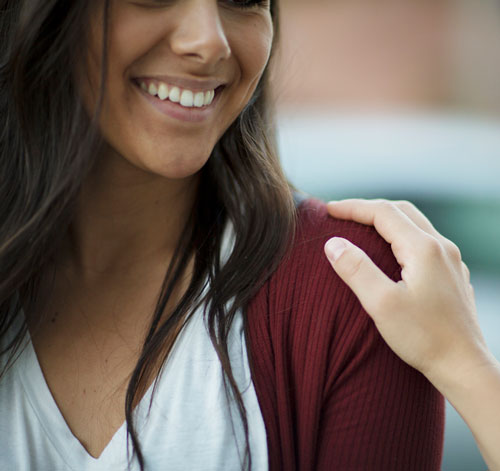 comforting hand on the shoulder of a woman